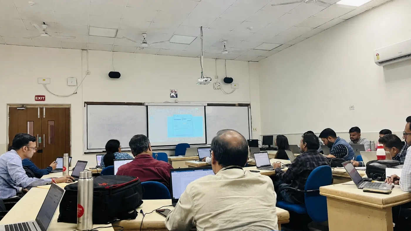 Trainer leading a classroom session with a data table on a projector screen